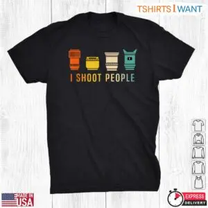 Flat lay black t-shirt featuring four retro striped camera lenses in orange, yellow, cream, and teal above I Shoot People text.