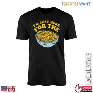Black Mac and Cheese T-Shirt flat lay with I'm Just Here For The arched over a baking dish of yellow pasta